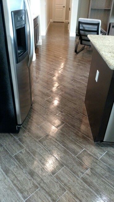 a kitchen with wood flooring and stainless steel appliances