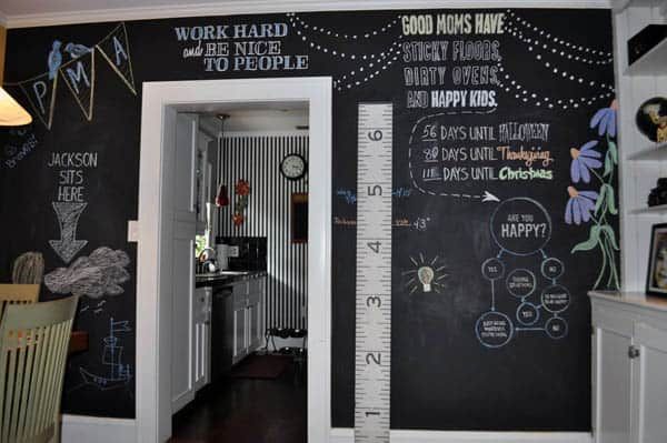 a chalkboard wall in a kitchen with writing on it and a height ruler hanging from the wall