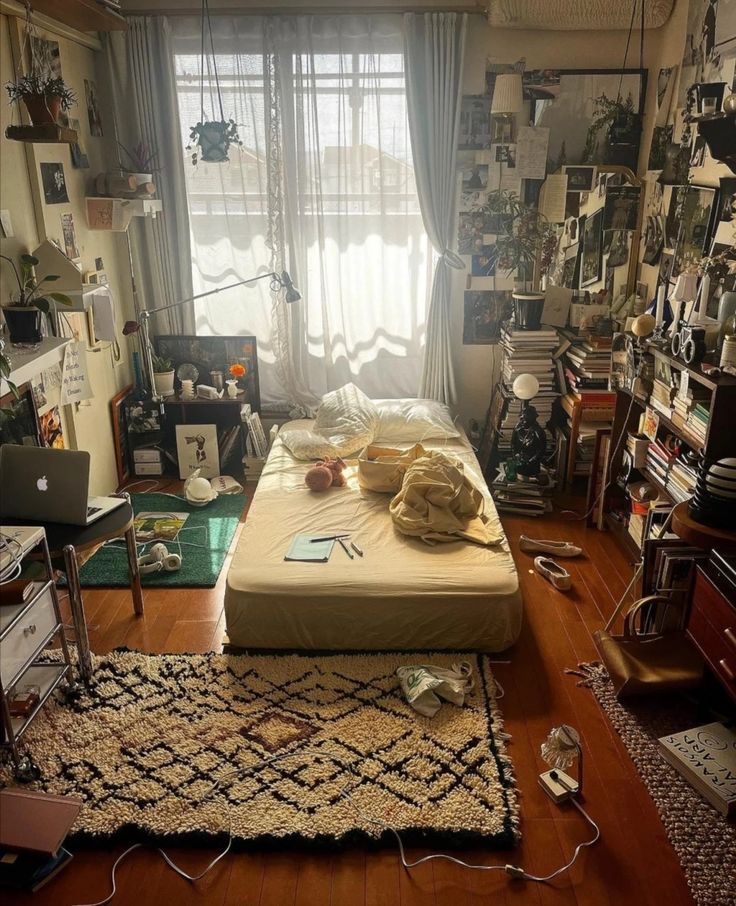 a bed sitting on top of a wooden floor in a bedroom next to a window