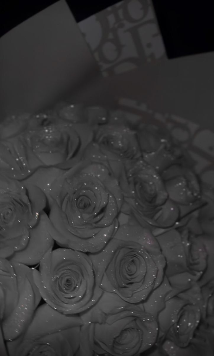 a bouquet of white roses sitting on top of a table