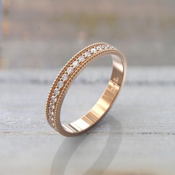 a gold ring with white diamonds on the outside, sitting on top of a table