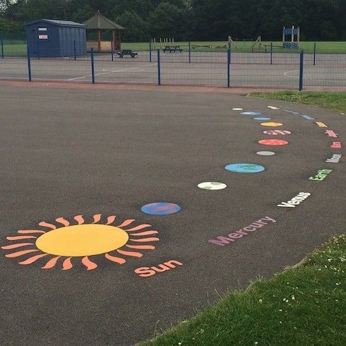 an empty playground with colorful chalk drawings on the ground