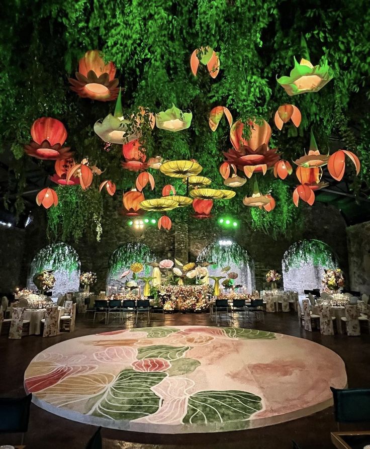 an elaborately decorated banquet hall with paper flowers hanging from the ceiling