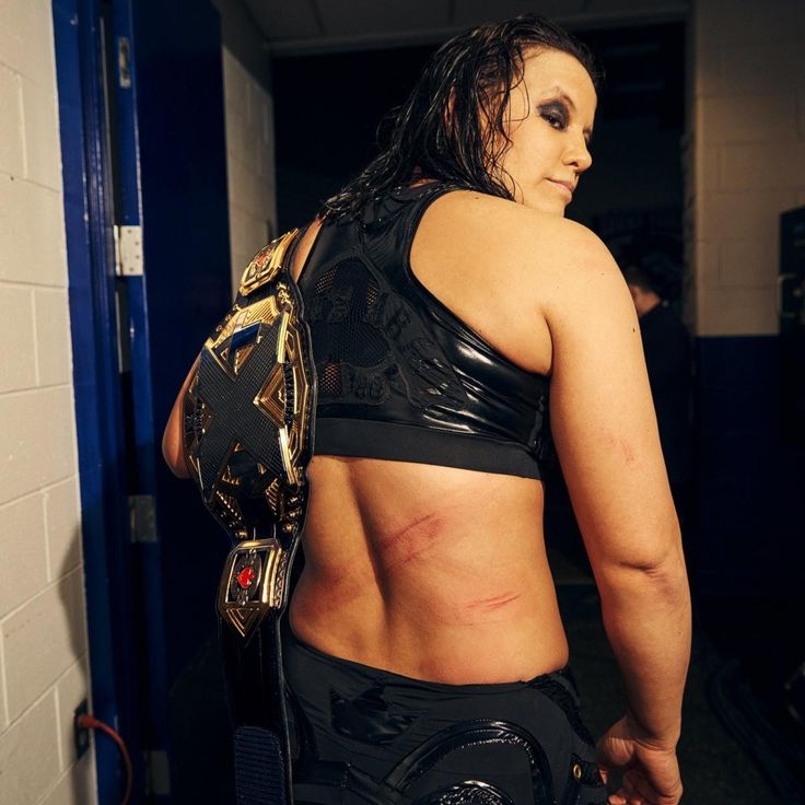 a woman in a wrestling outfit with her back to the camera