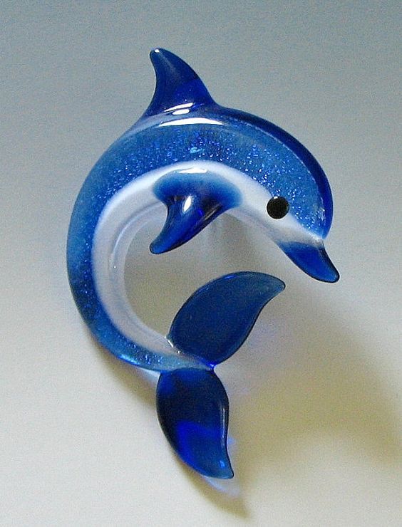 a blue and white dolphin figurine sitting on top of a table