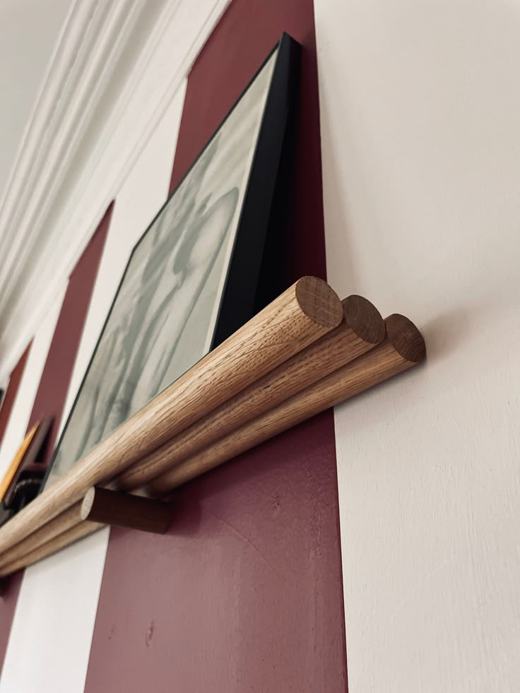 a wooden frame hanging on the side of a red and white wall next to a framed photo