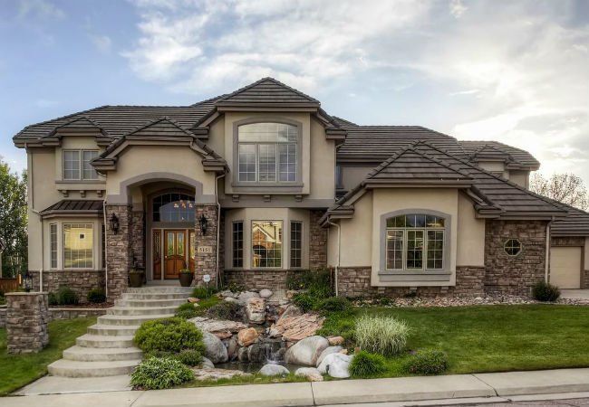 a large house with stone walls and landscaping