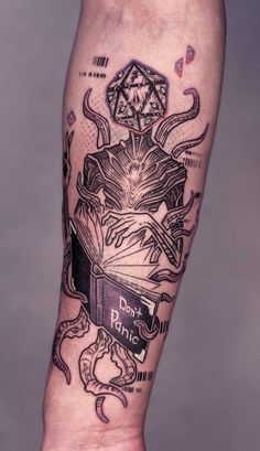 a man's leg with tattoos on it and an image of a demon reading a book