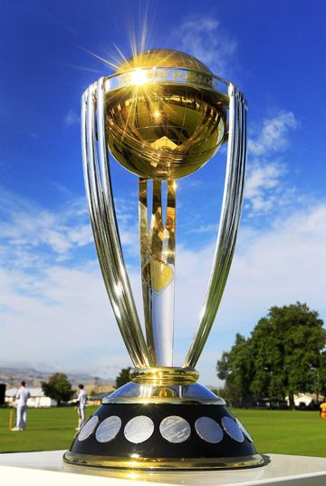 the cricket trophy is on display in front of a blue sky with clouds and trees