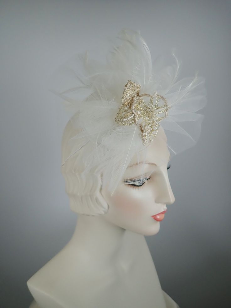 An elegant off-white fascinator perfect for a non-traditional wedding headpiece. It contains something old (vintage lace), something new (wire floral flower), and something blue (lining). The circular button base is covered in vintage white lace and then is topped with veiling, feathers and a gorgeous hand crocheted wire, bead and fabric flower grouping. Mounted on a narrow elastic band to help keep it in place. Upon request, I can remove the elastic band and mount it on a narrow headband. Beaut Adjustable Tulle Headpiece For Wedding, White Vintage Fascinator For Royal Ascot, Adjustable Tulle Fascinator For Wedding, White Vintage Headpiece For Formal Occasions, White Vintage Headpieces For Formal Occasions, Tulle Headband For Wedding, Adjustable Tulle Wedding Fascinator, Vintage White Formal Headpieces, Elegant Tulle Mini Hats For Wedding