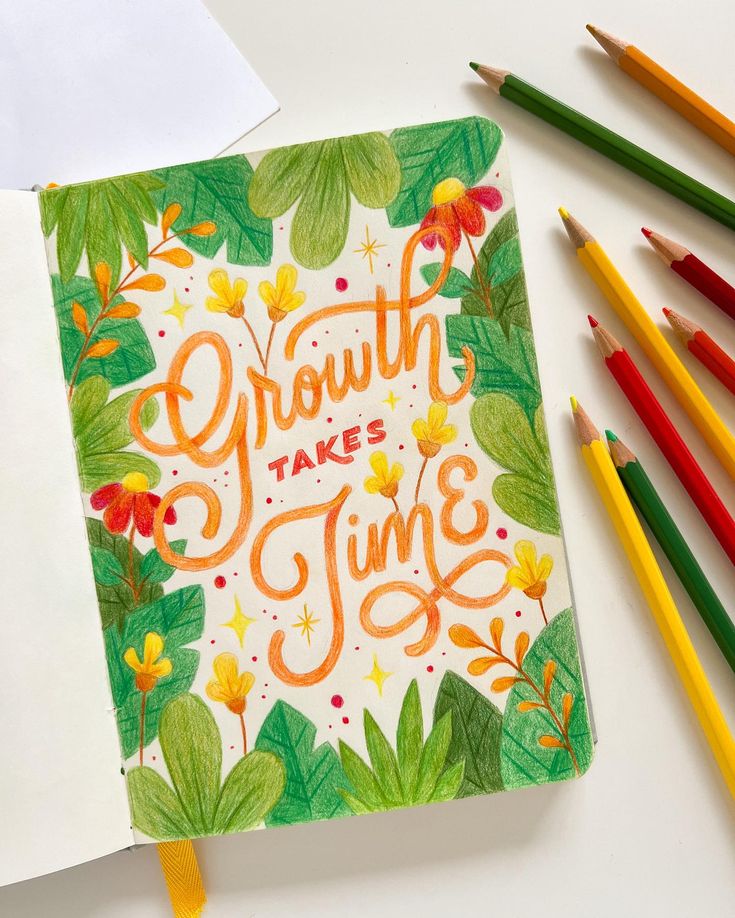 a notebook with the words growth takes time surrounded by colored pencils