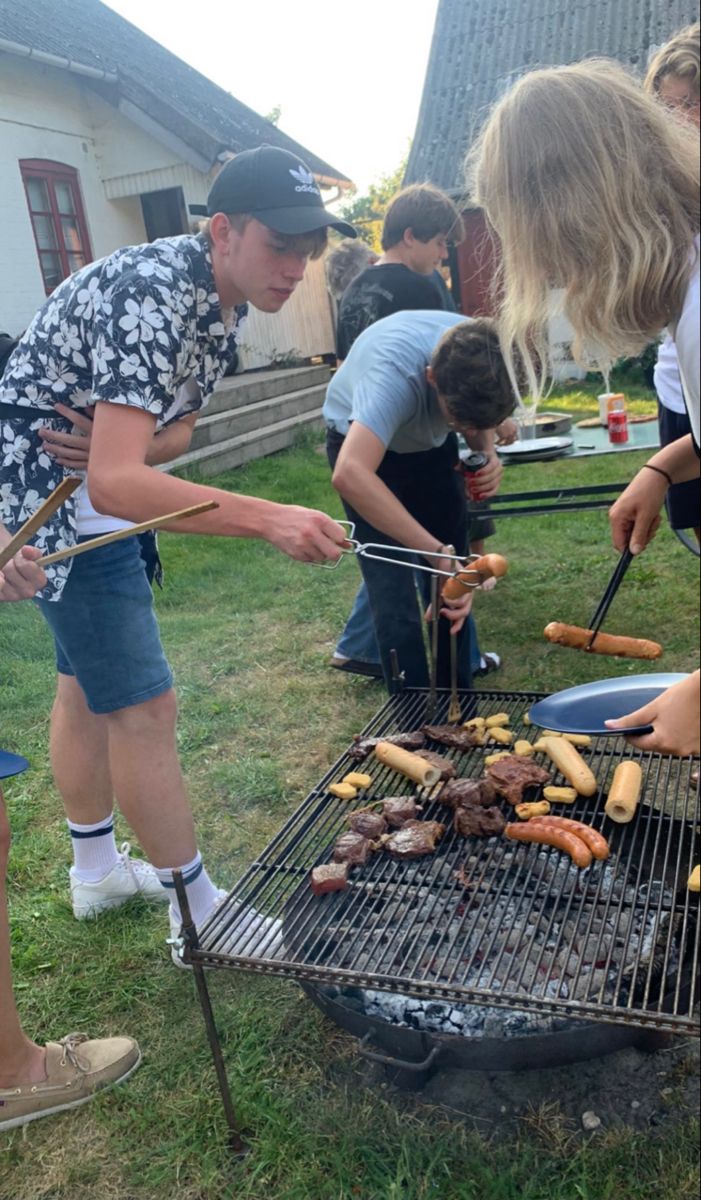 a group of people grilling hot dogs and hamburgers on an outdoor bbq