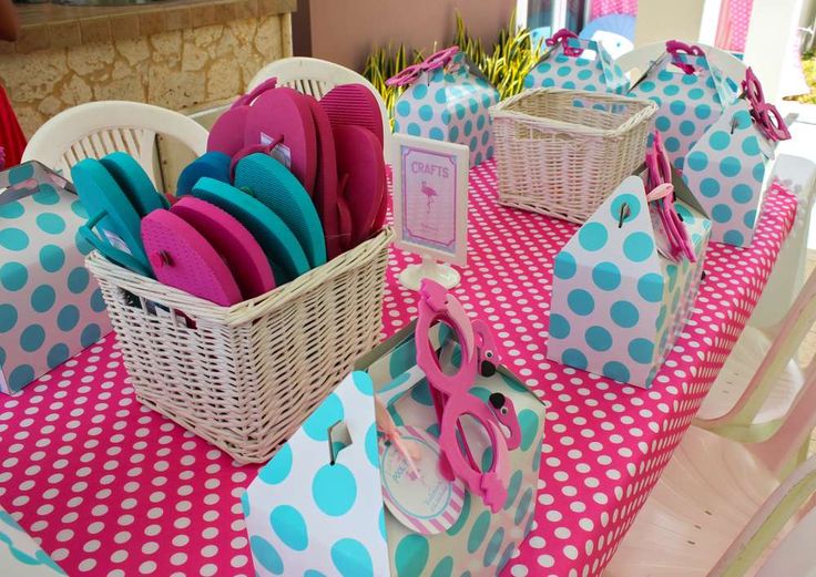 the table is set up with pink, blue and white polka dot napkins in baskets