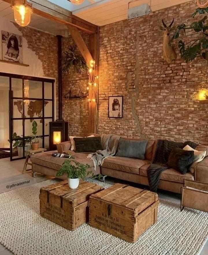 an image of a living room with brick walls and leather couches in the middle