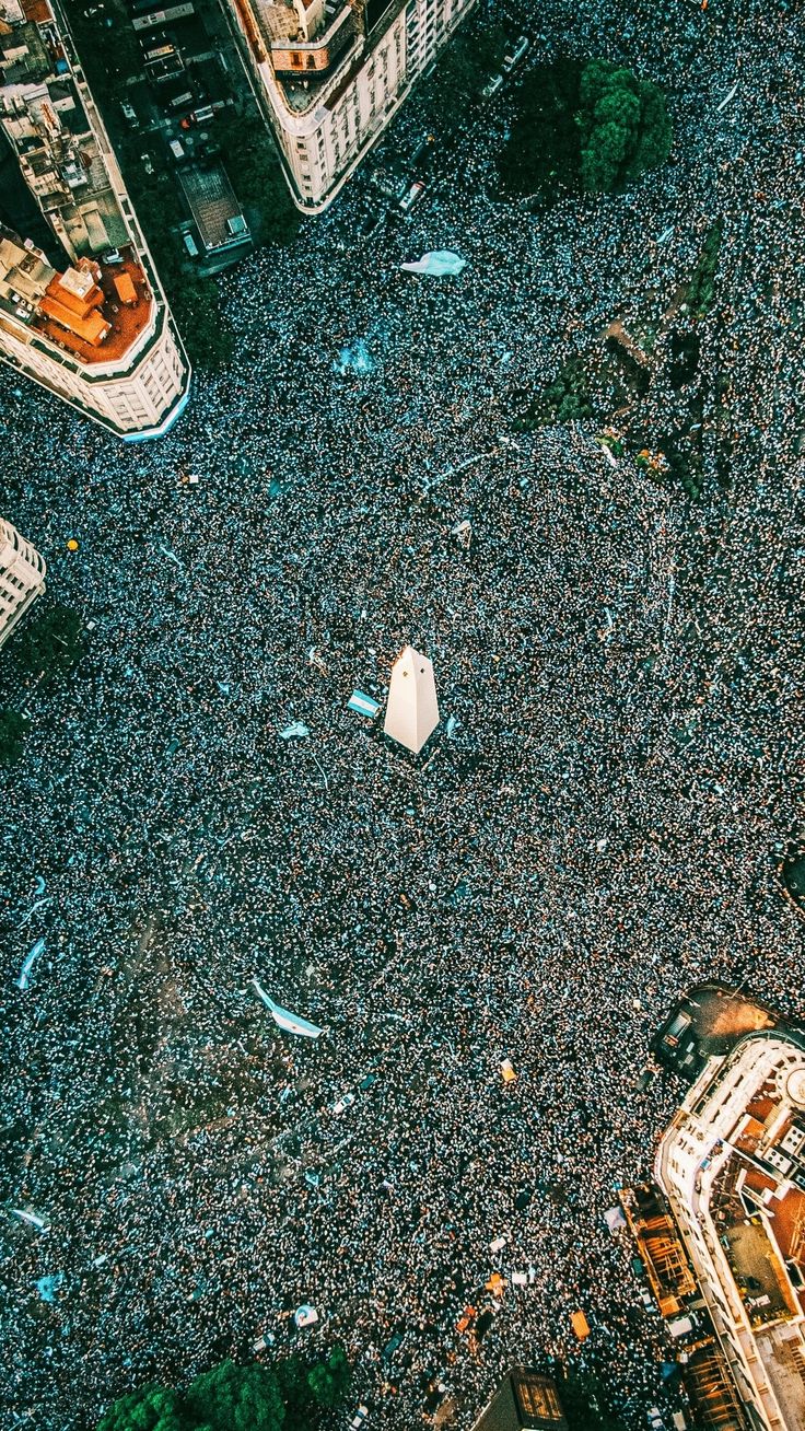 an aerial view of a large group of people in the middle of a city street