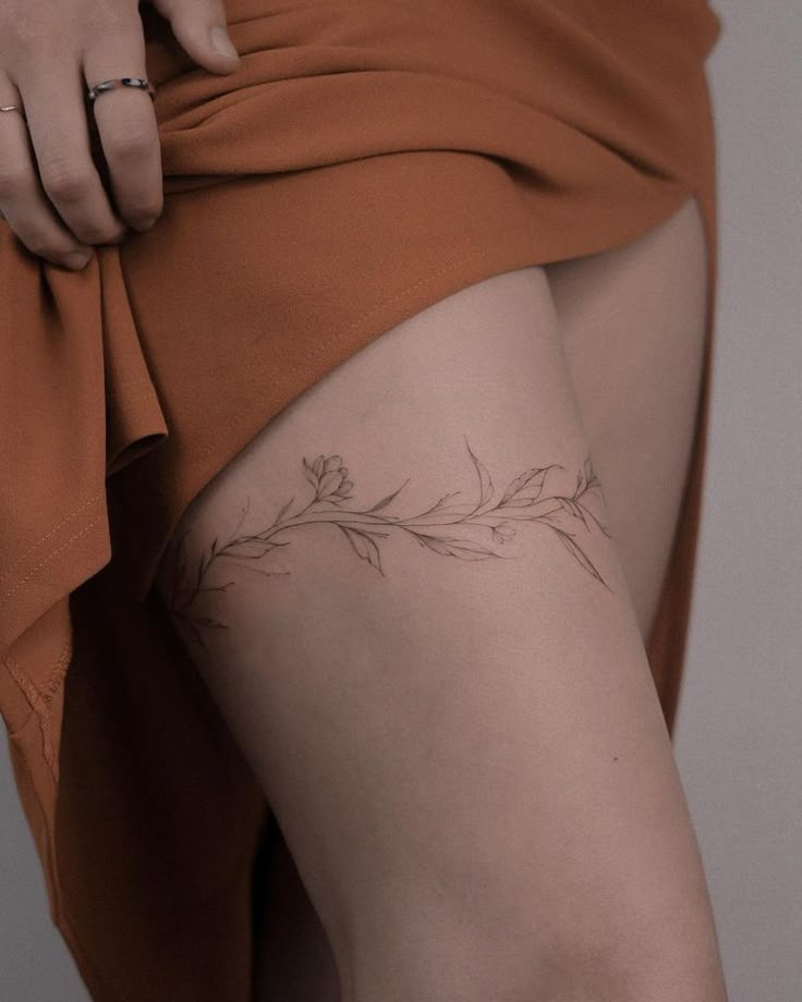 a close up of a person's leg with tattoos on it and a flower