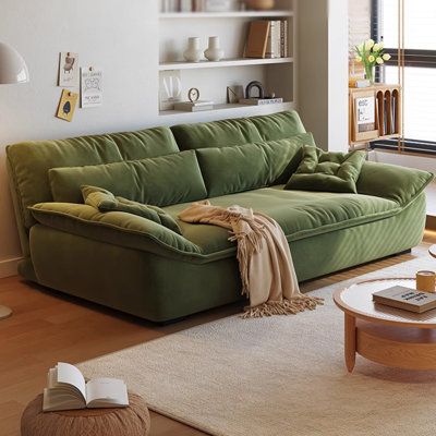 a living room with a green couch and coffee table