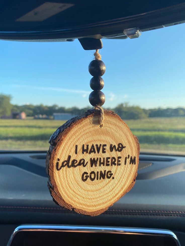 a piece of wood that says i have no idea where i'm going hanging from the dashboard of a car