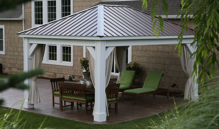 a white gazebo sitting on top of a patio next to a green lawn chair