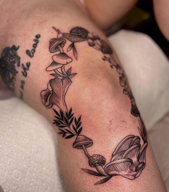 a woman's arm with flowers and leaves tattoo on her left side, while she is laying down