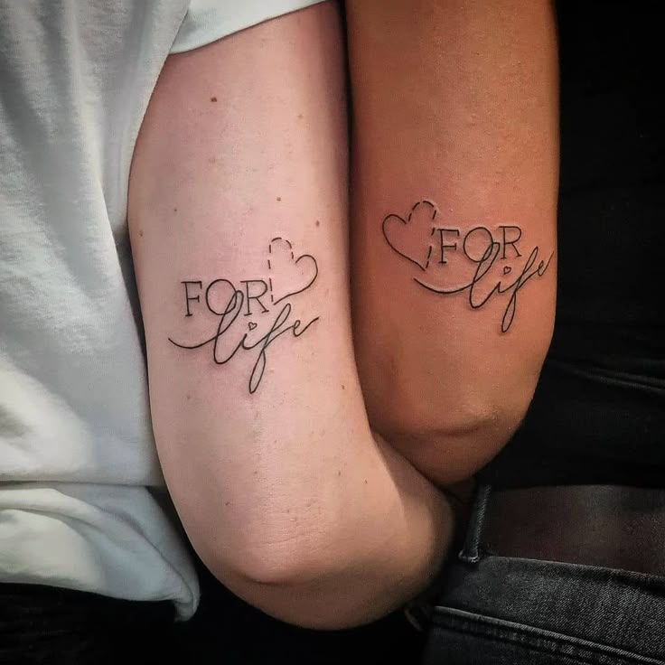 two people with tattoos on their arms that say for life and for life in cursive writing