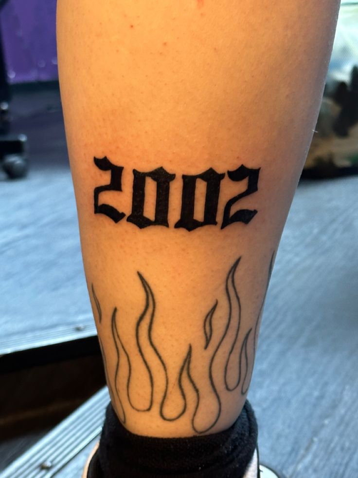 a close up of a person's leg with a tattoo on it that reads 2010