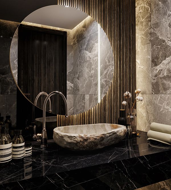 a bathroom with marble counter top and round mirror above the bathtub in front of it