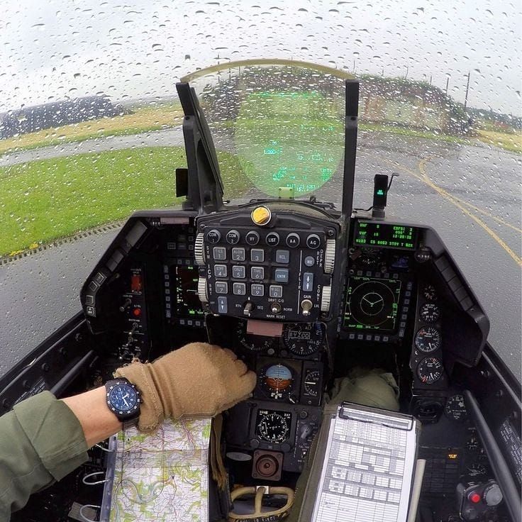 a person sitting in the cockpit of an airplane looking at a map and other items