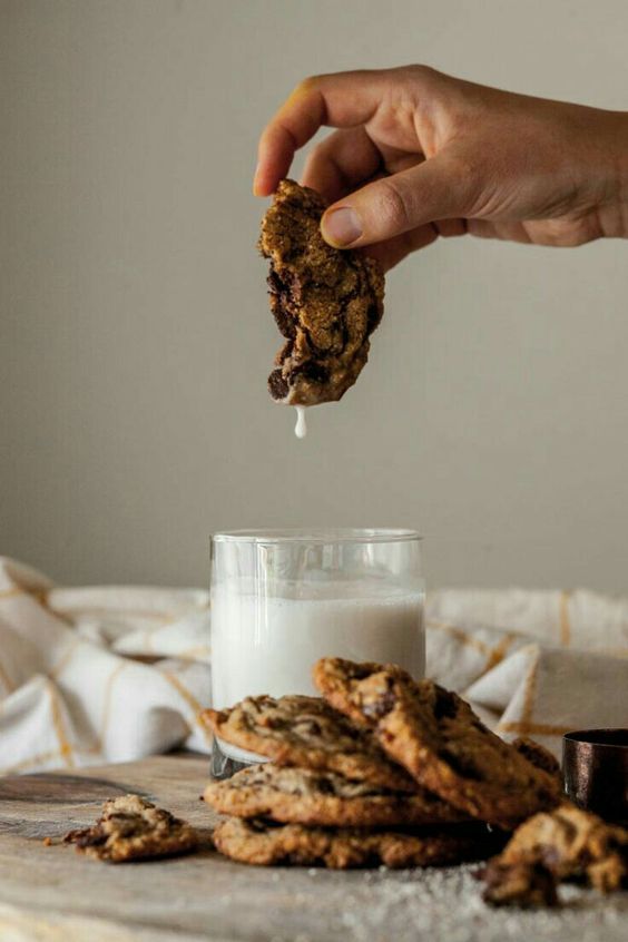 a person is dipping some cookies into a glass of milk