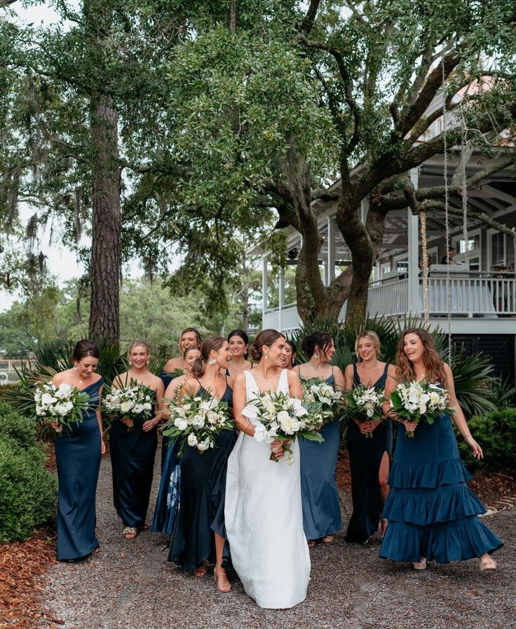 a bride and her bridal party in front of a tree at the beach house