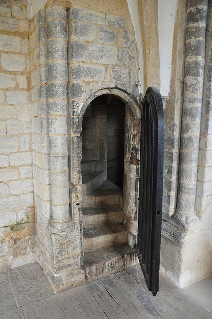 an old stone building with a door and some steps leading up to the entrance way