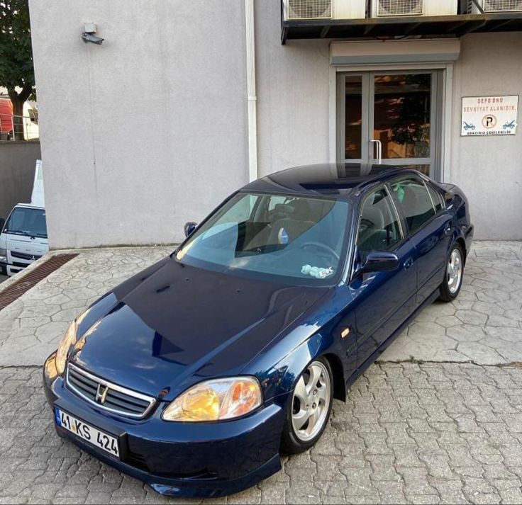 a blue car parked in front of a building