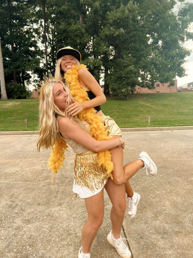 two young women are hugging each other in the middle of a parking lot with trees in the background