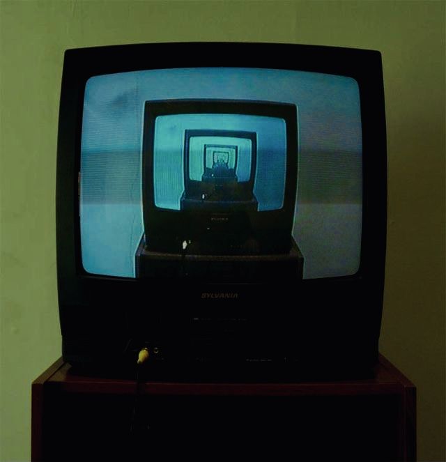 an old tv sitting on top of a wooden stand