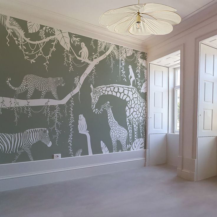 an empty room with zebras and giraffes painted on it's walls