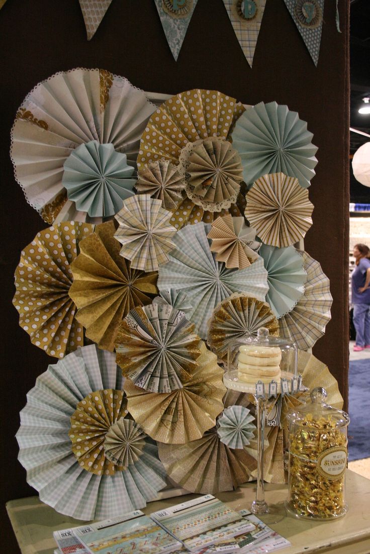 some paper fans are hanging on the wall next to a table with food and drinks