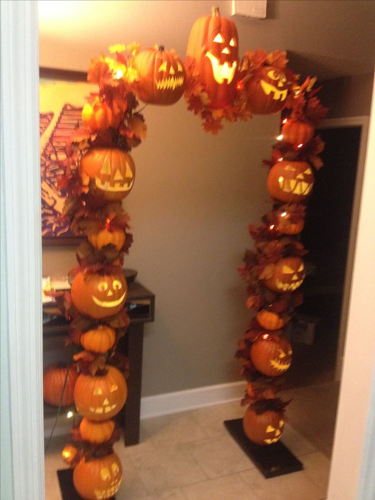 an arch made out of pumpkins with jack - o'- lanterns on them