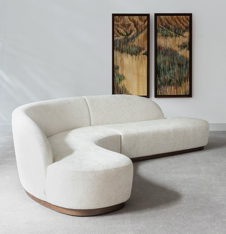 a large white couch sitting next to a painting on the wall in a living room