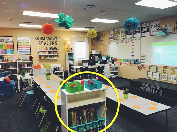 a classroom with desks, chairs and bookshelves