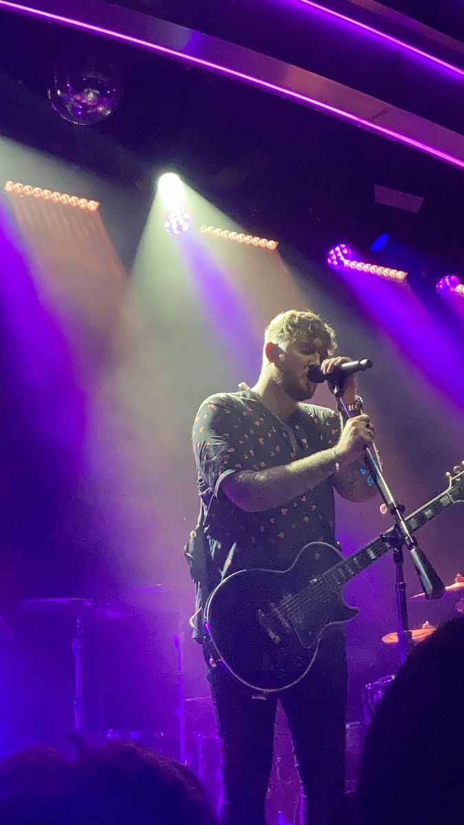 a man standing in front of a microphone on top of a stage