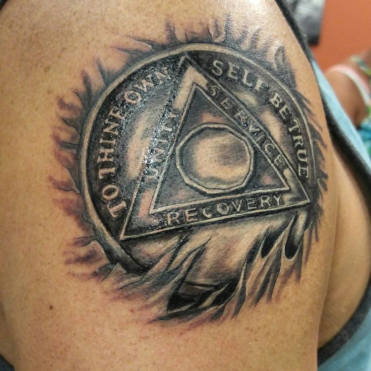 a man with a tattoo on his shoulder has a triangle and an eye in the center