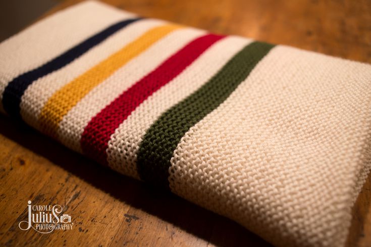 a striped blanket sitting on top of a wooden table