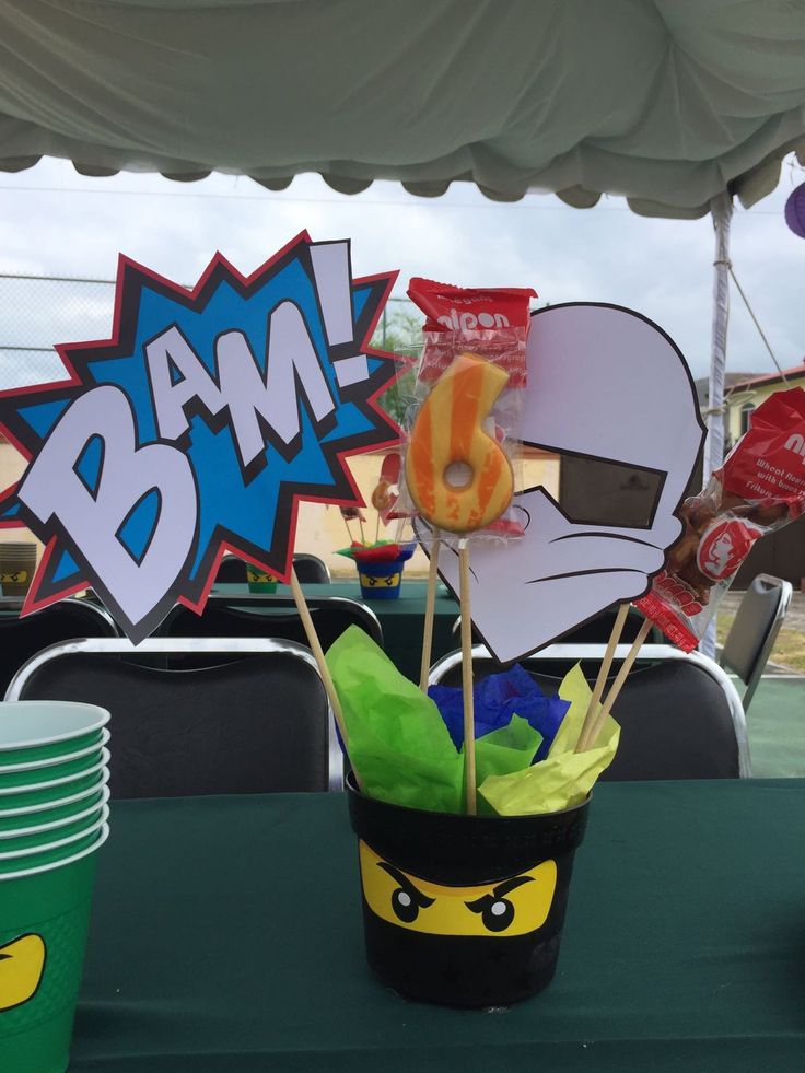 a table topped with a cup filled with donuts next to a sign that says bam