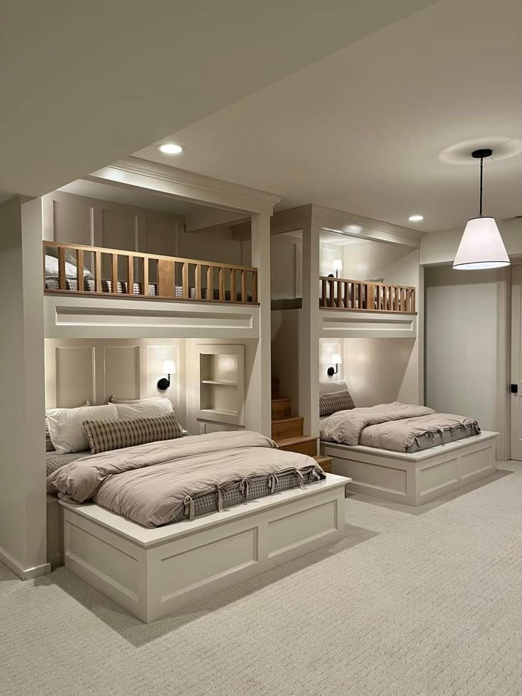 a bedroom with two beds and a loft above it is lit by lights on either side of the bed