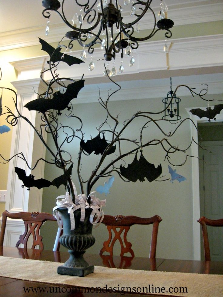 a dining room table decorated with bats and chandelier