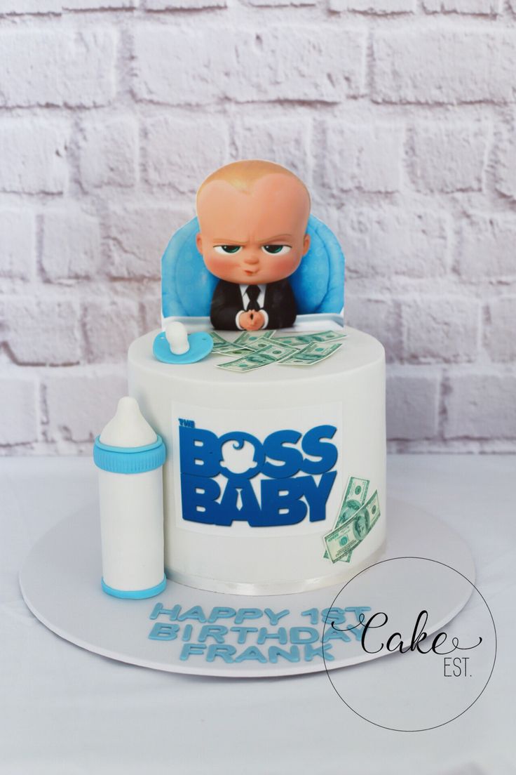 a cake that has a baby on top with the words boss baby written on it