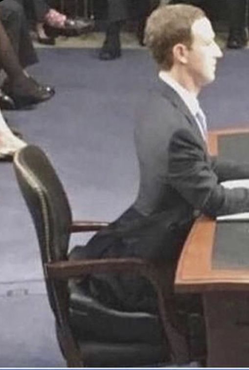 a man sitting at a desk in front of a laptop computer