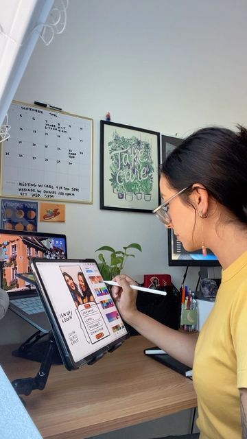 a woman is looking at an image on a computer screen while holding a pencil in her right hand