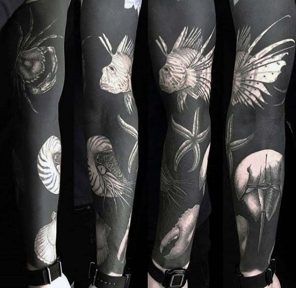 several different tattoos on both arms and legs, one is black and white the other is grey