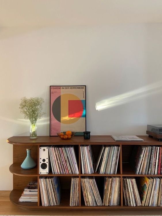 a record player is sitting on top of a shelf filled with vinyl records and cds